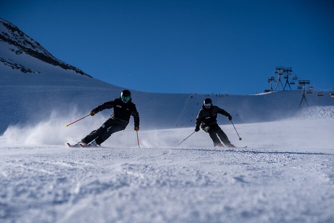 Two skiers carving down a groomed run above Zermatt